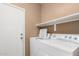 A well-equipped laundry room includes a washer, dryer, and storage shelf for convenience at 28232 N Abby Cir, San Tan Valley, AZ 85143
