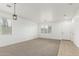 Bright and airy living room with neutral carpet, a modern light fixture, and ample natural light at 28232 N Abby Cir, San Tan Valley, AZ 85143