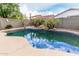 Backyard swimming pool features rock waterfall, lush palms, and beautiful reflection of the sky above at 28232 N Abby Cir, San Tan Valley, AZ 85143
