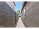 Narrow side yard with a beige concrete walkway and gravel extending between a block wall and the house at 28232 N Abby Cir, San Tan Valley, AZ 85143