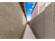 Narrow side yard with a beige concrete walkway and gravel extending between a beige house and a block wall at 28232 N Abby Cir, San Tan Valley, AZ 85143