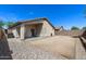 Spacious backyard with gravel and dirt landscaping, a covered patio, and block wall fencing at 30100 N Sunray Dr, San Tan Valley, AZ 85143