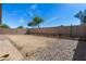 Spacious dirt backyard framed with gravel and a block wall offering a blank canvas for landscaping at 30100 N Sunray Dr, San Tan Valley, AZ 85143