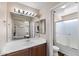 Well-lit bathroom featuring a vanity with sink, a large mirror, and a glass-enclosed shower at 30100 N Sunray Dr, San Tan Valley, AZ 85143