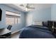 Cozy blue bedroom featuring a ceiling fan, closet, window, and sleek desk at 30100 N Sunray Dr, San Tan Valley, AZ 85143