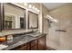 Beautiful bathroom with a glass-enclosed shower and a unique sink with a dark marble countertop at 30285 W Leah Dr, Buckeye, AZ 85396