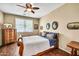Bright bedroom with window views, showcasing antique wood furniture and warm, inviting decor at 30285 W Leah Dr, Buckeye, AZ 85396