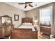 Bright bedroom showing an antique wooden bed frame, a ceiling fan and a dresser at 30285 W Leah Dr, Buckeye, AZ 85396