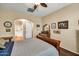 A cozy bedroom features a wood-framed bed, arched doorway, and a glimpse of the bathroom at 30285 W Leah Dr, Buckeye, AZ 85396