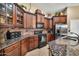 Gourmet kitchen featuring granite countertops, dark wood cabinets, and stainless steel appliances at 30285 W Leah Dr, Buckeye, AZ 85396