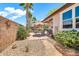 Charming patio area with decorative brick pavers, desert landscaping, and a dining set with umbrella at 30285 W Leah Dr, Buckeye, AZ 85396