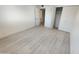 A bright bedroom has modern floors, closet, and white painted walls at 3208 W Bloomfield Rd, Phoenix, AZ 85029