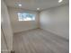 Neutral bedroom with laminate flooring, a window bringing in natural light, and a clean, minimalist design at 3208 W Bloomfield Rd, Phoenix, AZ 85029