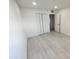Minimalist bedroom features laminate flooring, a closet, and a light-filled atmosphere with crisp white walls at 3208 W Bloomfield Rd, Phoenix, AZ 85029