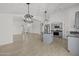 Open-concept kitchen features an island, gray cabinets, stainless steel appliances, and modern pendant lighting at 3843 E Citrine Rd, San Tan Valley, AZ 85143