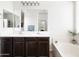 Bathroom with a double sink vanity, large mirror, and soaking tub, offering a spa-like experience at 3952 E Frances Ln, Gilbert, AZ 85295