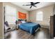 Comfortable bedroom with wood floors, ceiling fan, a modern chair, and an arched window at 3952 E Frances Ln, Gilbert, AZ 85295