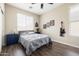 Cozy bedroom featuring wood floors, a ceiling fan, and unique wall art, creating a stylish space at 3952 E Frances Ln, Gilbert, AZ 85295