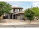 Charming two-story home featuring a tile roof, arched entryway, and a well-manicured front yard with mature trees at 3952 E Frances Ln, Gilbert, AZ 85295