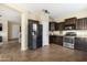 Well-lit kitchen featuring dark wood cabinets, stainless steel appliances, and tile flooring at 3952 E Frances Ln, Gilbert, AZ 85295