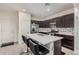 Modern kitchen featuring a spacious island with seating, stainless steel appliances, and dark cabinetry at 4044 S 58Th Ln, Phoenix, AZ 85043