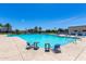 Community pool featuring clear water, lounge chairs, and tables for residents to relax and enjoy sunny days at 4044 S 58Th Ln, Phoenix, AZ 85043