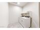 Clean laundry room with a stacked washer and dryer unit and a built-in shelf for storage at 42920 W Palo Amarillo Rd, Maricopa, AZ 85138