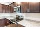 Contemporary kitchen with granite countertops, stainless steel appliances, and dark wood cabinets at 42960 W Palo Amarillo Rd, Maricopa, AZ 85138