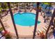 Aerial view of a community pool with lounge chairs, palm trees, and a gazebo with seating at 44158 W Canyon Creek Dr, Maricopa, AZ 85139