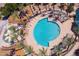 Overhead view of a community pool and recreation area, featuring lounge chairs and colorful playground equipment at 44158 W Canyon Creek Dr, Maricopa, AZ 85139
