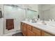 Bright bathroom featuring a double sink vanity and a glass-enclosed shower at 44158 W Canyon Creek Dr, Maricopa, AZ 85139