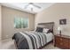 Cozy bedroom featuring a window, a bed, a ceiling fan, and a bedside table at 44158 W Canyon Creek Dr, Maricopa, AZ 85139