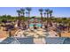 Aerial view of the community pool area with modern structures, lounge chairs, and a splash pad at 44158 W Canyon Creek Dr, Maricopa, AZ 85139