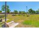 Community recreation area with horseshoe pits, grassy field, mature trees, and benches at 44158 W Canyon Creek Dr, Maricopa, AZ 85139