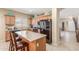 Charming kitchen with wood cabinets, stone countertops, modern appliances, and island with seating at 44158 W Canyon Creek Dr, Maricopa, AZ 85139