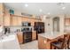 Well-lit kitchen showcases light wood cabinets, granite countertops, and modern black appliances at 44158 W Canyon Creek Dr, Maricopa, AZ 85139