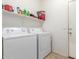 Laundry room featuring a white washer, dryer, and a shelf with supplies at 44158 W Canyon Creek Dr, Maricopa, AZ 85139