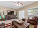 Cozy living room with sliding door to the yard, stylish furniture, and a ceiling fan at 44158 W Canyon Creek Dr, Maricopa, AZ 85139