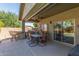 Covered patio with a dining area, a built-in grill, and a seamless transition to the home's interior at 44158 W Canyon Creek Dr, Maricopa, AZ 85139