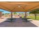 Inviting community picnic pavilion with shaded tables and barbeque grills for outdoor enjoyment at 44158 W Canyon Creek Dr, Maricopa, AZ 85139