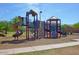 Community playground featuring modern play structures, slides, and climbing features at 44158 W Canyon Creek Dr, Maricopa, AZ 85139