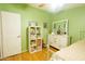 Bright bedroom with wooden floors, a ceiling fan, a full dresser, and a white shelving unit at 501 E Ray Rd # 36, Chandler, AZ 85225