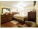 Spacious bedroom featuring wood floors, a ceiling fan, and a large dresser with a mirror at 501 E Ray Rd # 36, Chandler, AZ 85225