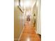 Long hallway with wood floors, framed pictures, and access to multiple rooms, showcasing the home's layout at 501 E Ray Rd # 36, Chandler, AZ 85225
