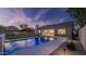 Backyard featuring a pool, a custom stone waterfall, landscaped lawn, and outdoor lighting at 5103 E Juniper Ave, Scottsdale, AZ 85254
