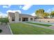 Backyard features a pool, gravel landscaping, lush green grass, and neutral-toned stucco home at 5103 E Juniper Ave, Scottsdale, AZ 85254