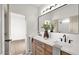 Bathroom with double sinks, granite counters, wood cabinets, and large framed mirror at 5103 E Juniper Ave, Scottsdale, AZ 85254