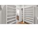 Spacious walk-in closet with built-in shelving and hardwood floors leading to the bath at 5103 E Juniper Ave, Scottsdale, AZ 85254