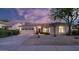 Home exterior features a three-car garage, desert landscaping, and a beautiful sunset sky at 5103 E Juniper Ave, Scottsdale, AZ 85254