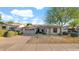 Charming single-story home featuring desert landscaping, a large shade tree, and an attached two-car garage at 5103 E Juniper Ave, Scottsdale, AZ 85254